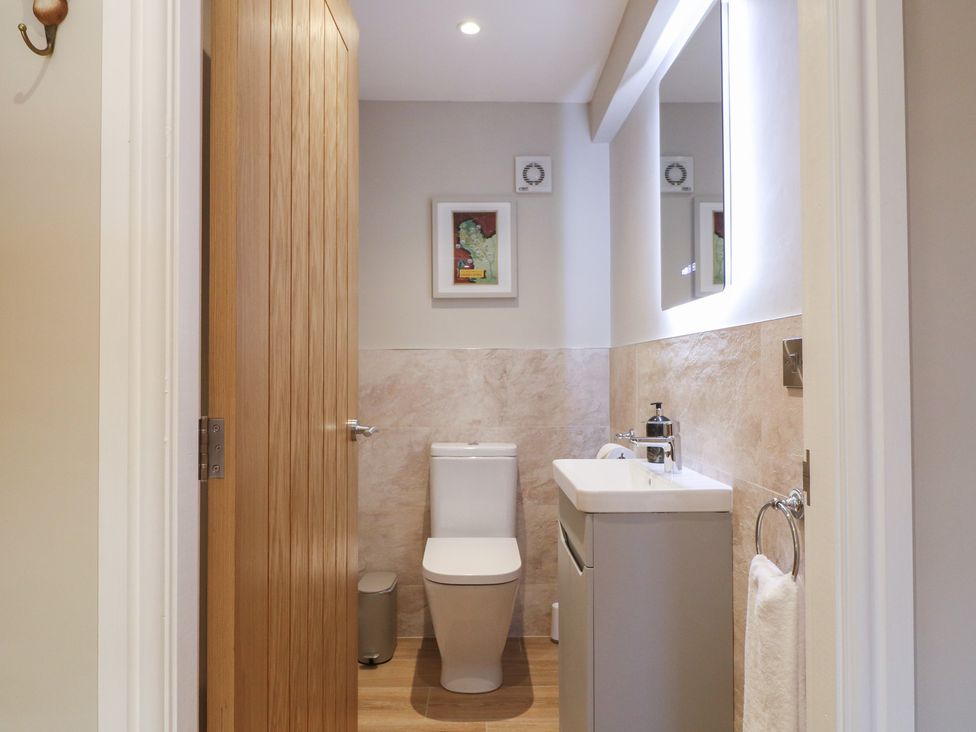 A bathroom with a toilet and sink at The Coach House in Holloway
