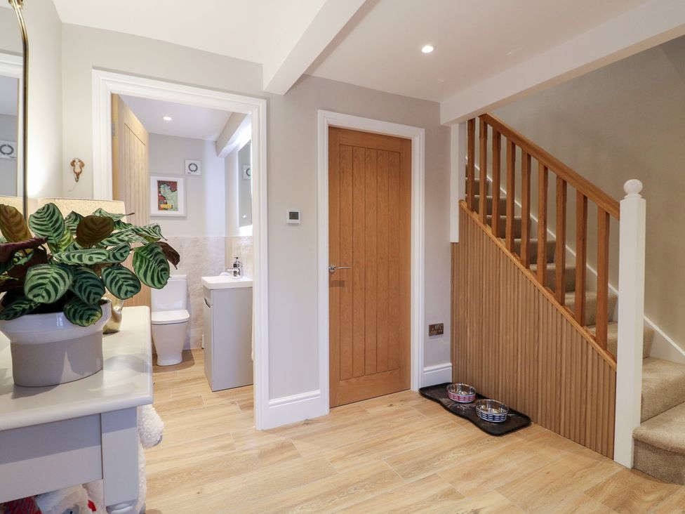 A hallway with stairs, door and plant at The Coach House in Holloway