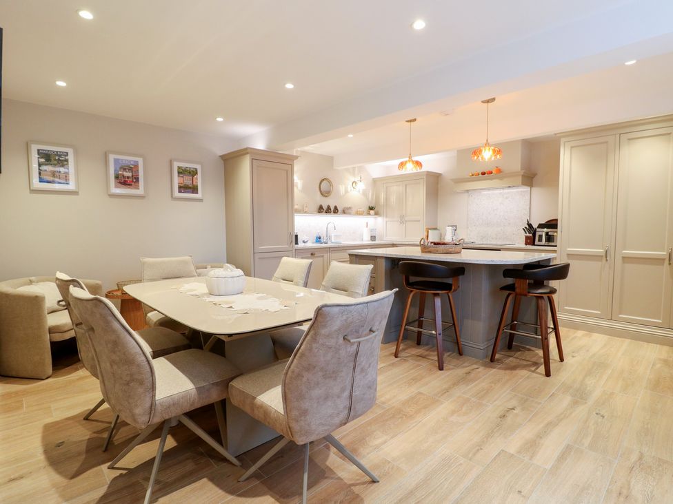 A kitchen with a dining area and bar stools at The Coach House in Holloway