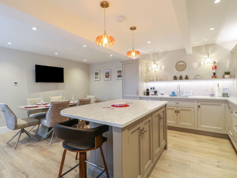 A kitchen with dining area and modern fixtures at The Coach House in Holloway