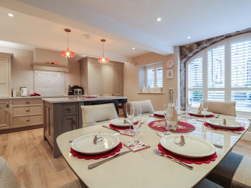 A kitchen with a dining area featuring a table and chairs at The Coach House in Holloway