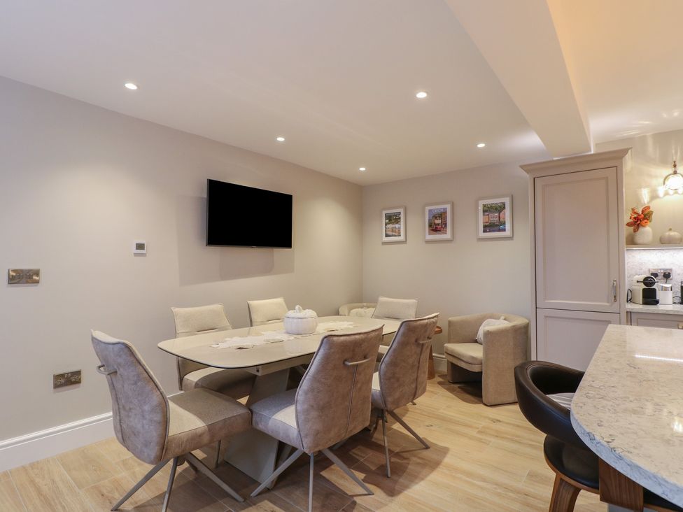 A dining room with a table and chairs at The Coach House in Holloway