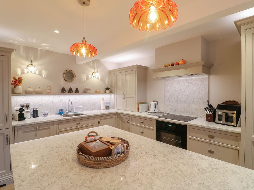 A kitchen with cabinets and a countertop at The Coach House in Holloway