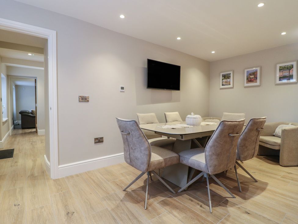 A dining room with a table and chairs at The Coach House in Holloway