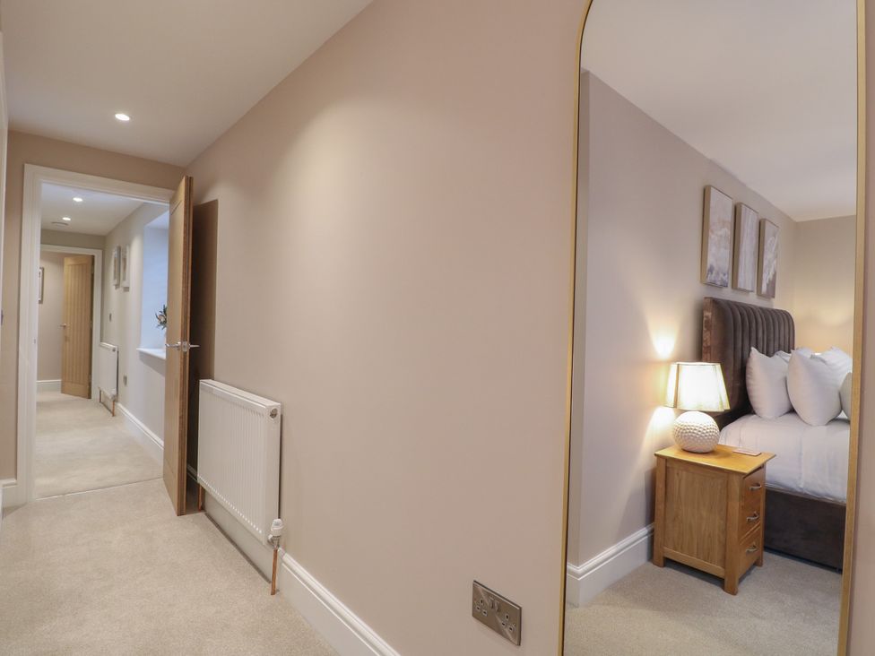 A hallway with a door and a view into a bedroom at The Coach House in Holloway