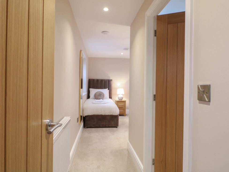 A bedroom with a bed and lamp at The Coach House in Holloway