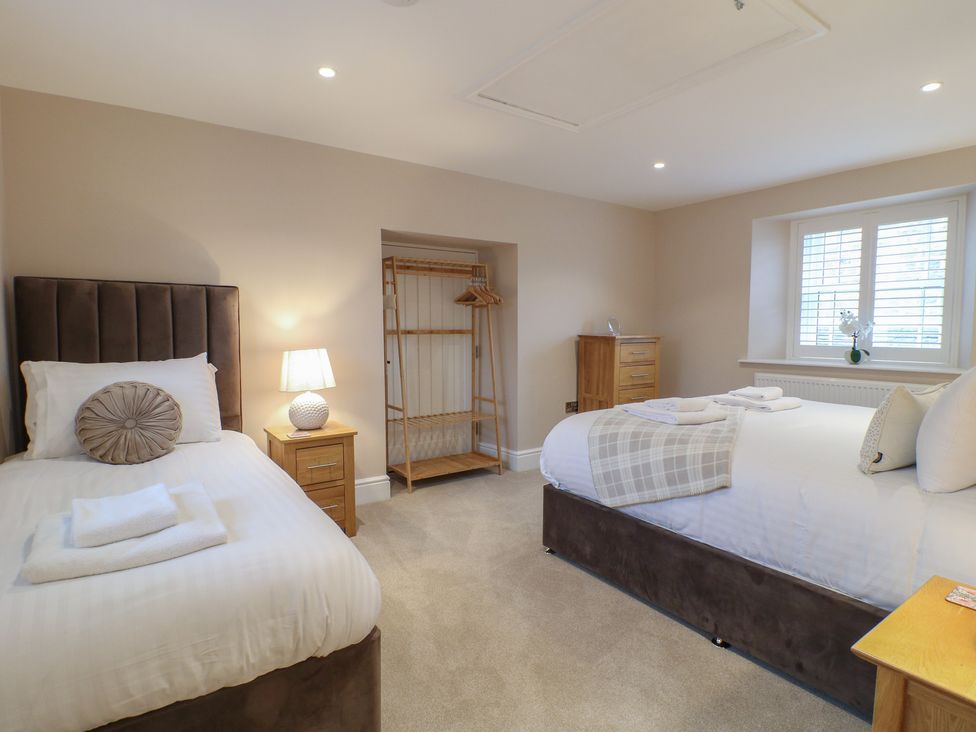 A bedroom with two beds and a wardrobe at The Coach House in Holloway