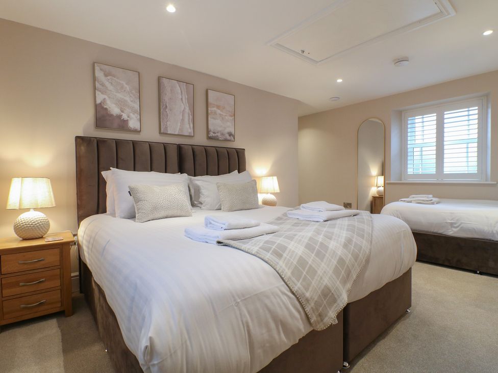 A bedroom with a double bed and a twin bed at The Coach House in Holloway