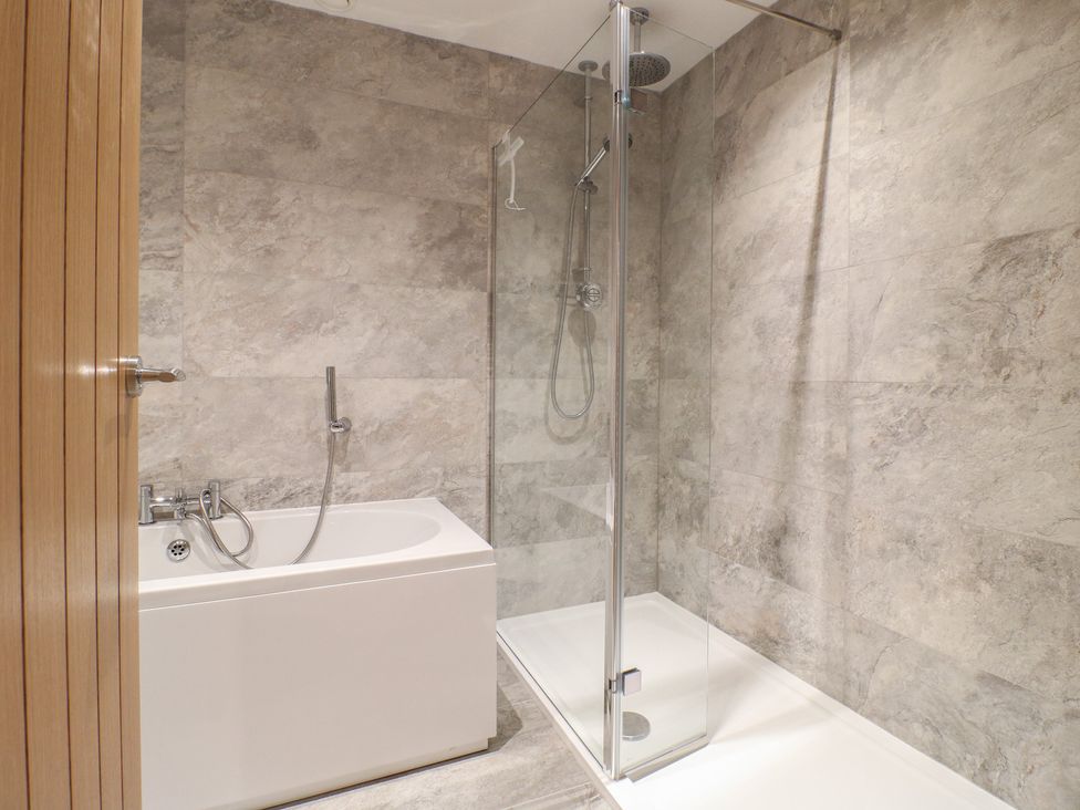 A bathroom with a bathtub and shower at The Coach House in Holloway