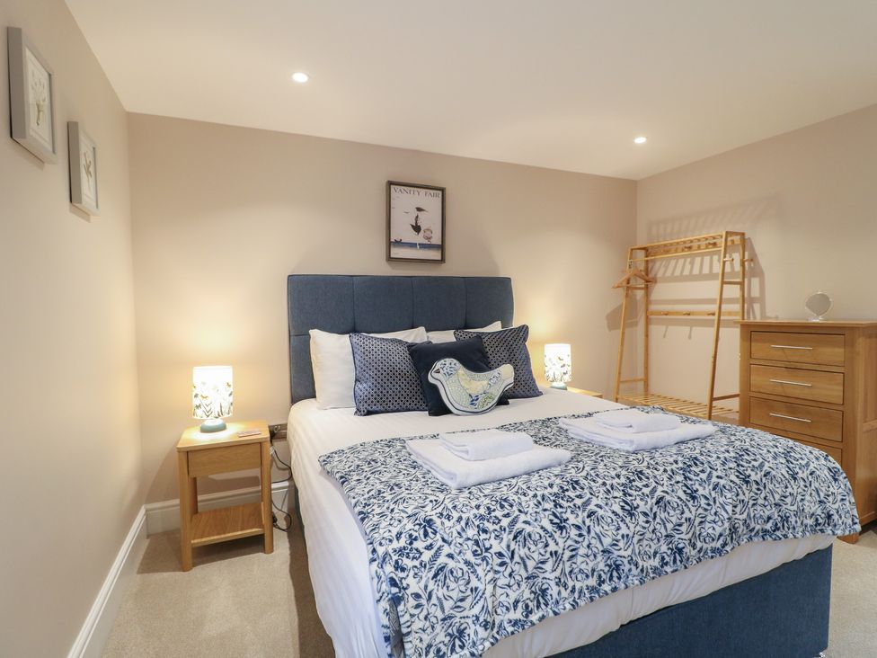 A bedroom with a bed and side tables at The Coach House in Holloway