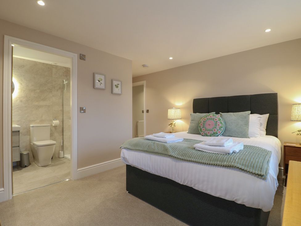 A bedroom with a bed and an adjoining bathroom at The Coach House in Holloway