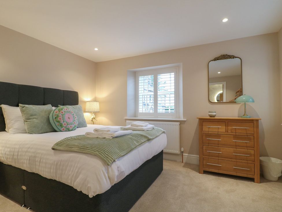 A bedroom with a bed and dresser at The Coach House in Holloway