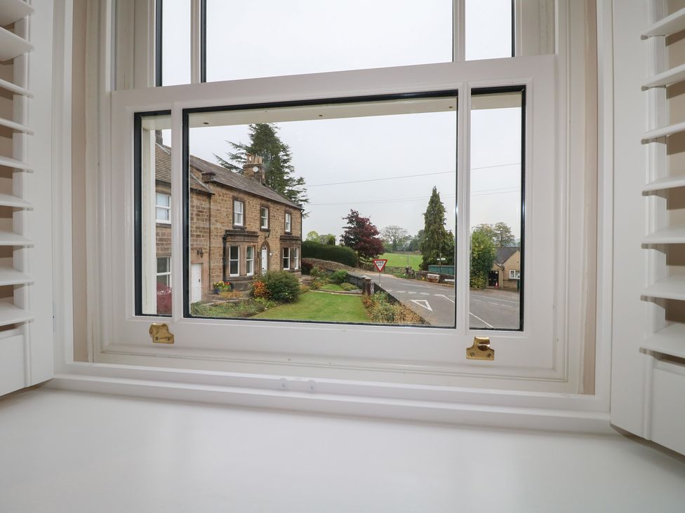 A view from a window showing a house and garden at The Coach House in Holloway