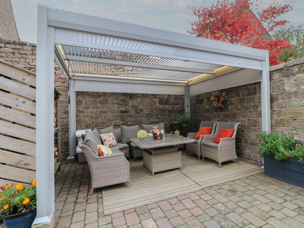 An outdoor living area with seating and a table at The Coach House in Holloway
