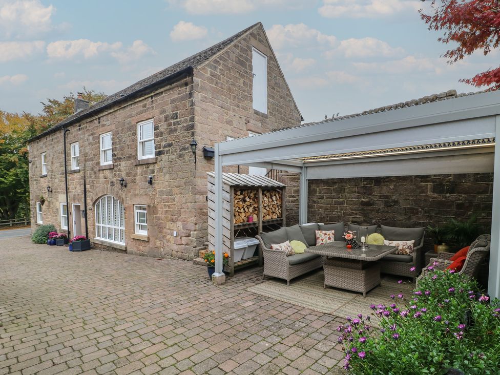 An outdoor seating area with a sofa and table at The Coach House in Holloway