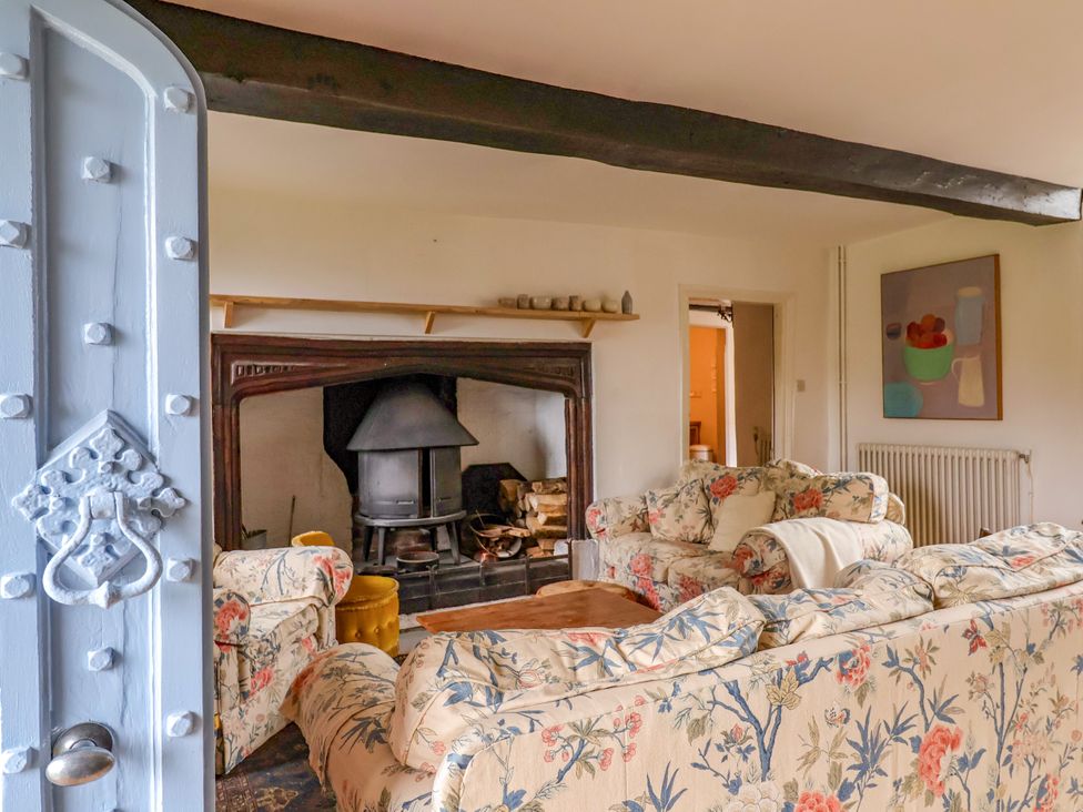 A living room with a fireplace and sofas at Hole House in Branscombe