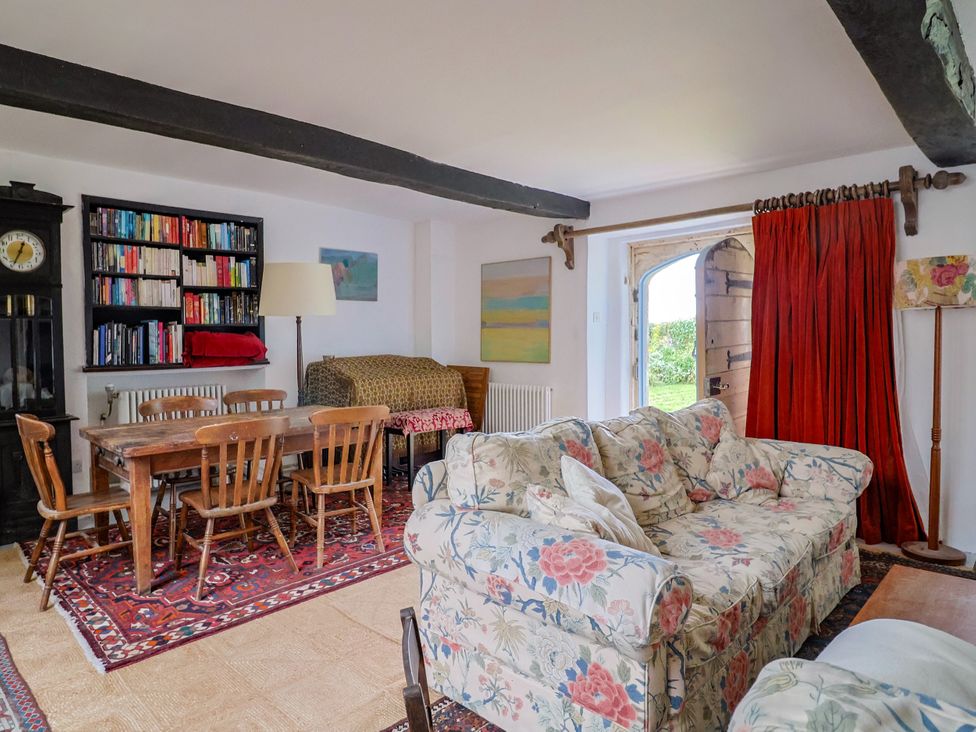 A living room with a dining table and sofa at Hole House in Branscombe