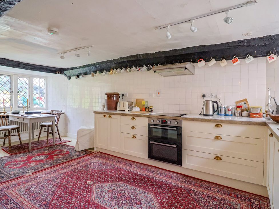 A kitchen with modern appliances and dining table at Hole House in Branscombe
