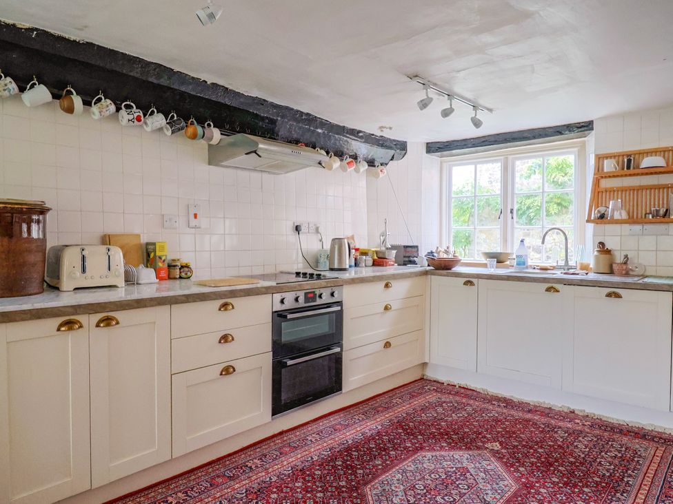 A kitchen with cabinets and appliances at Hole House in Branscombe