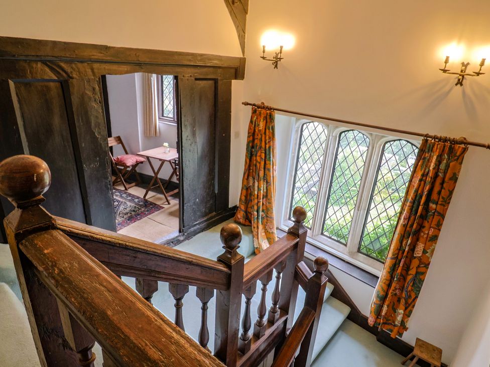 A staircase with a window and table at Hole House in Branscombe