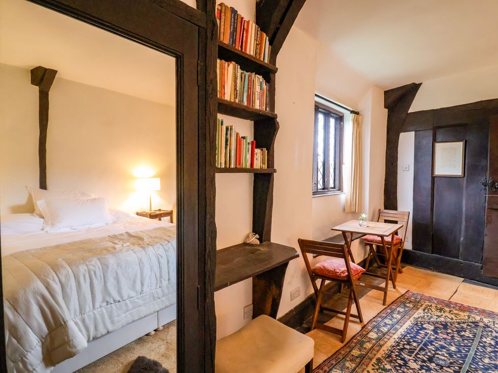 A bedroom with a bed and bookshelf at Hole House in Branscombe