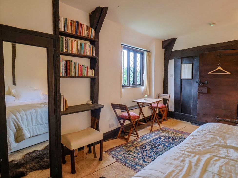 A bedroom with a bed and bookshelf at Hole House in Branscombe