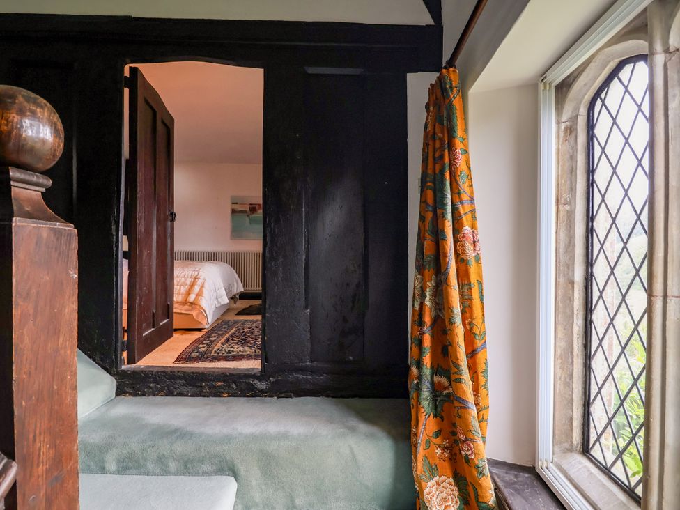 A view of a bedroom with a door and window at Hole House in Branscombe