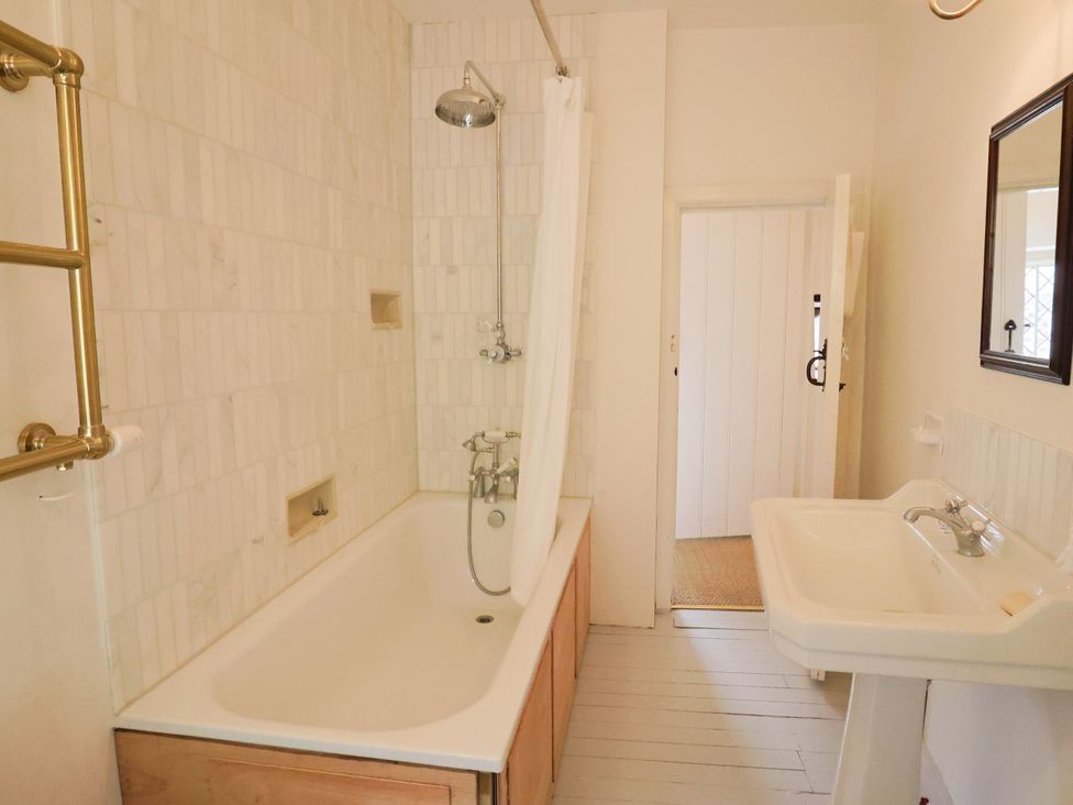 A bathroom with a bathtub and sink at Hole House in Branscombe