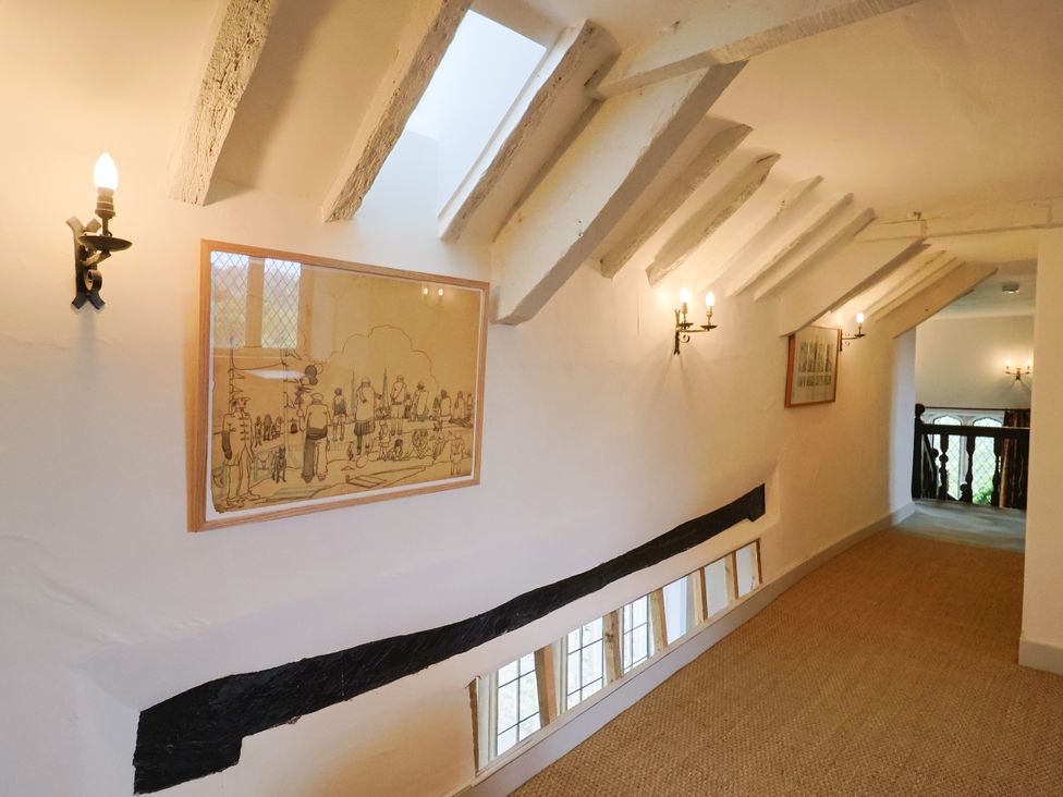 A corridor with artwork and light fixtures at Hole House in Branscombe