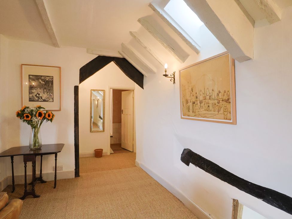 A hallway with flowers on a table at Hole House in Branscombe