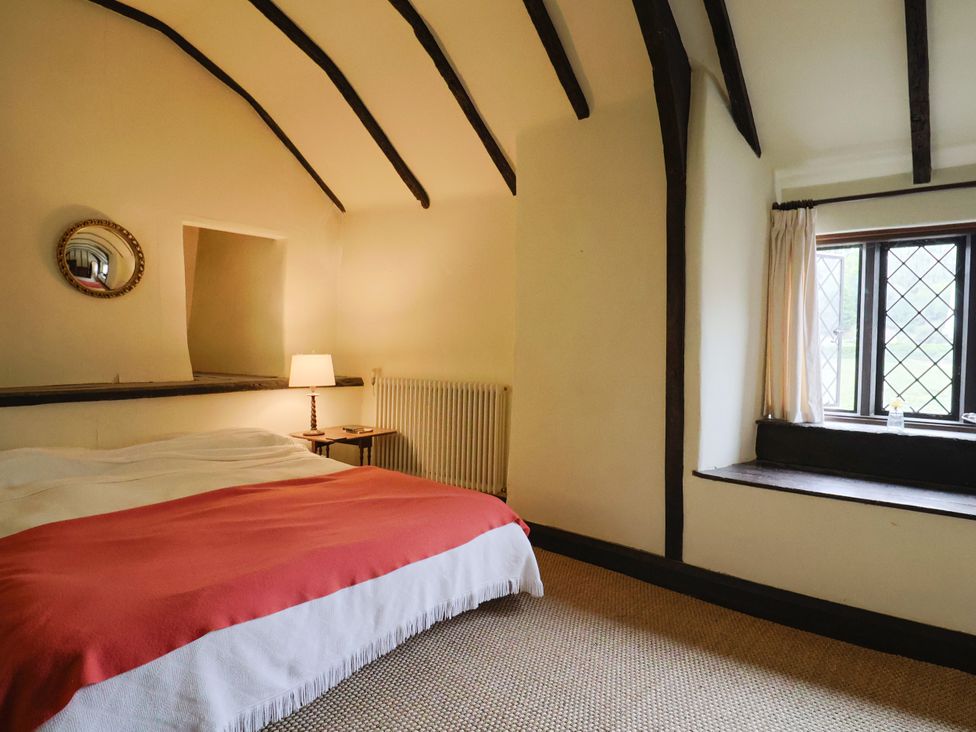 A bedroom with a bed and window at Hole House in Branscombe