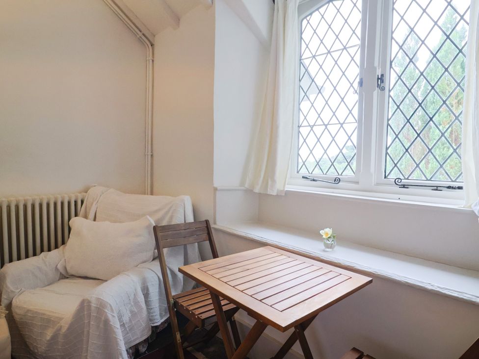 A sitting room with an armchair and wooden table at Hole House in Branscombe