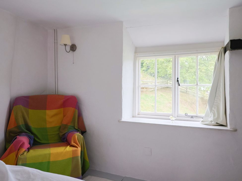 A room with a chair and window at Hole House in Branscombe