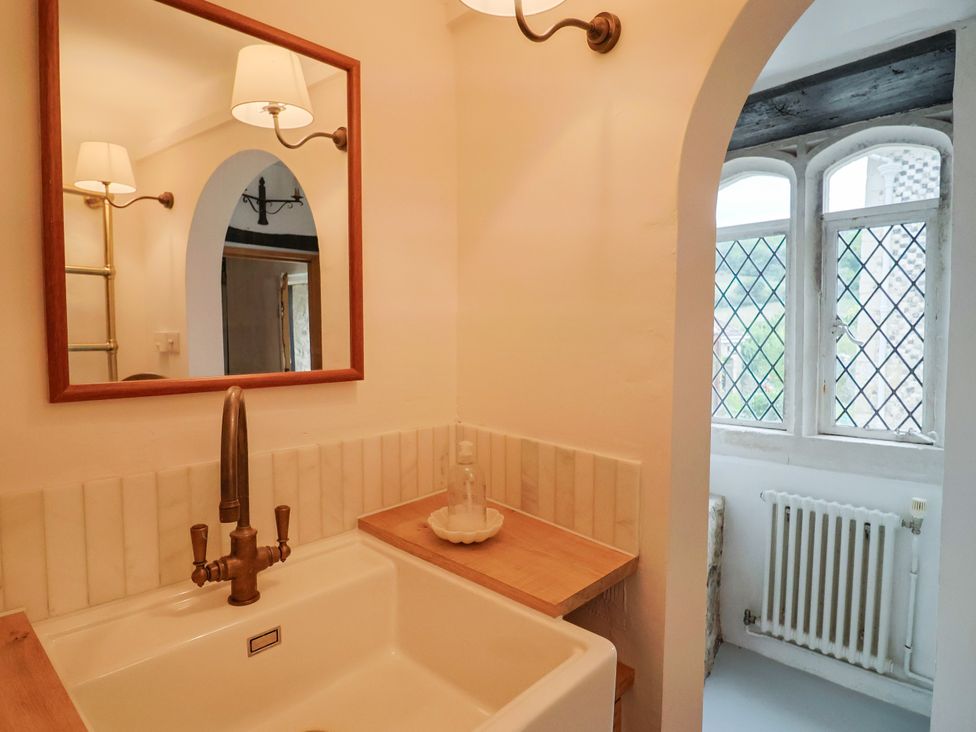 A bathroom with a sink and mirror at Hole House in Branscombe