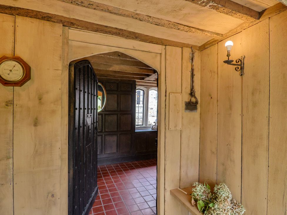 An entrance hall with a wooden door and clock at Hole House in Branscombe