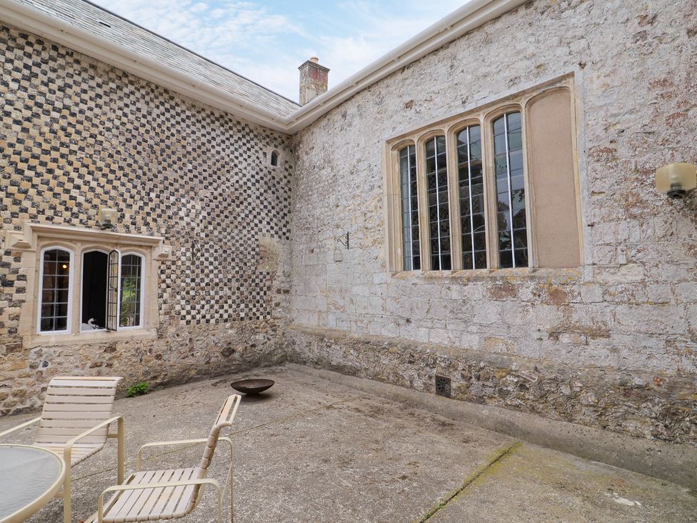 An outdoor area with stone walls and a table with chairs at Hole House in Branscombe