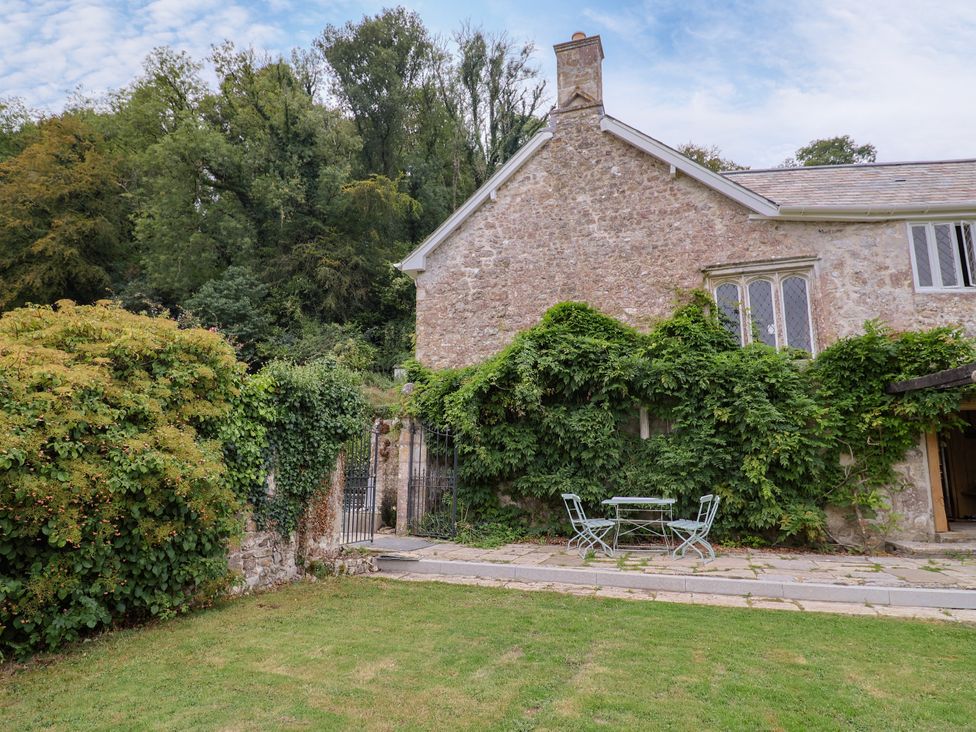 A garden with a table and chairs at Hole House in Branscombe