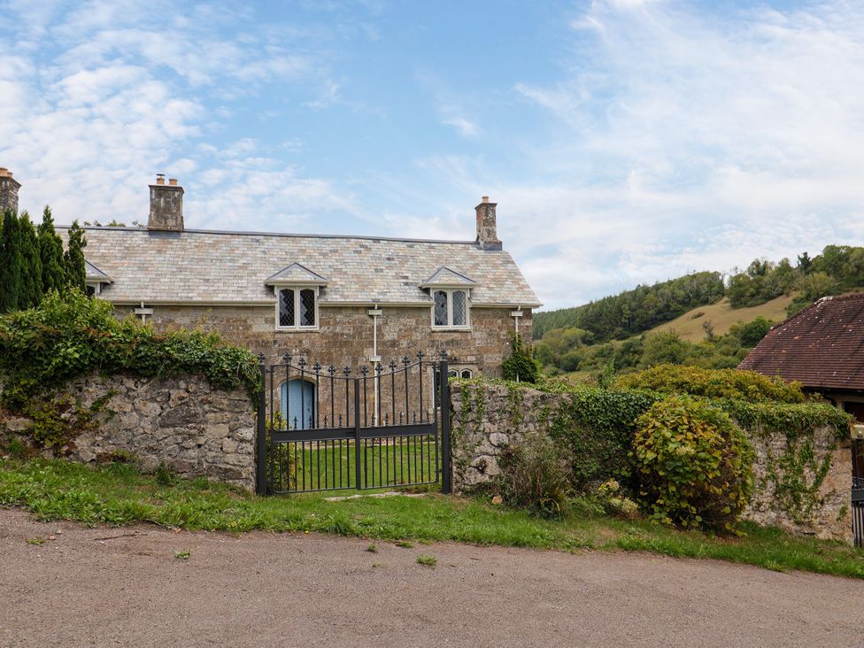 A house with a gate and stone wall at Hole House in Branscombe