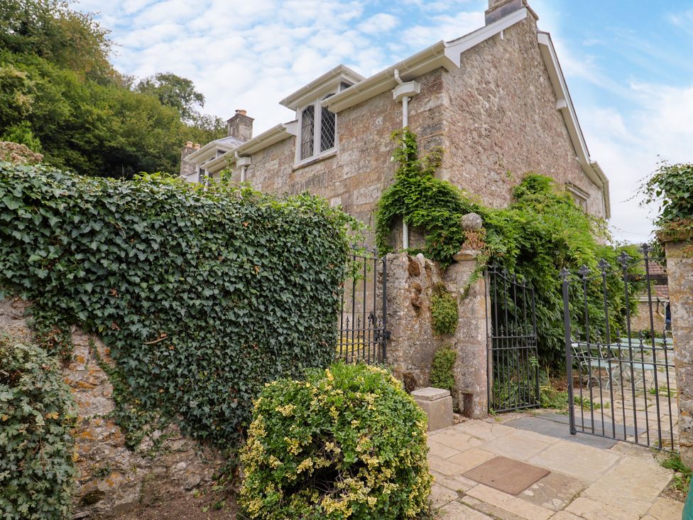 A garden entrance with gate and greenery at Hole House in Branscombe