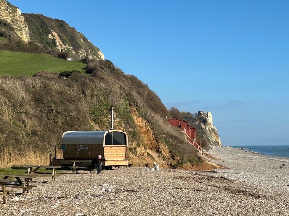 A beach with a wooden cabin and picnic table at Hole House, Branscombe