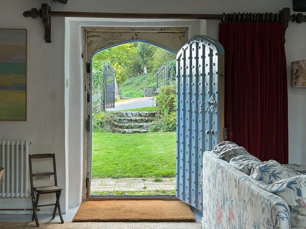 An entrance view with an open door leading to a garden at Hole House in Branscombe