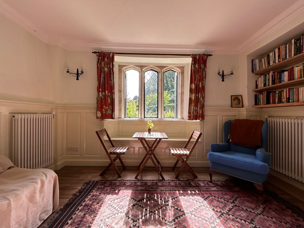 A sitting room with chairs and a table at Hole House in Branscombe