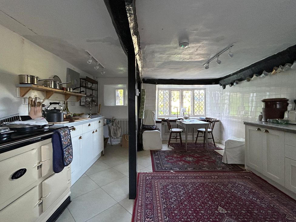 A kitchen with a stove and table at Hole House in Branscombe