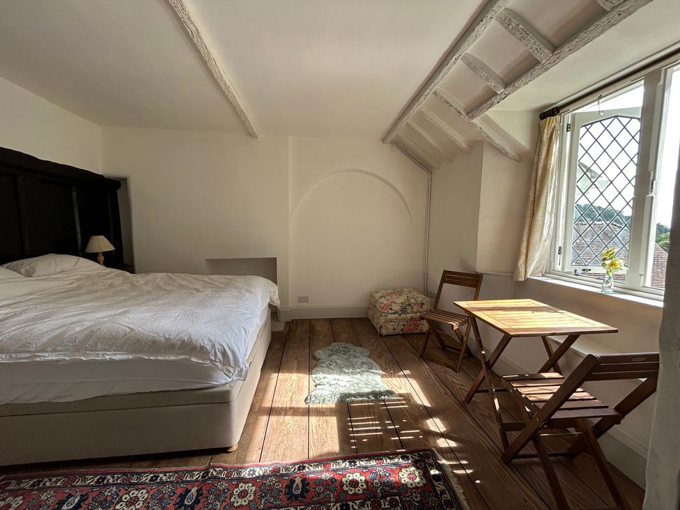 A bedroom with a bed and dining table at Hole House in Branscombe