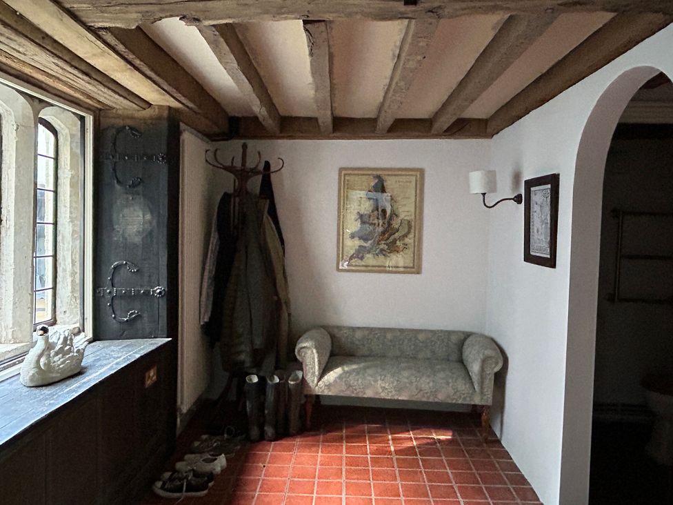 A hallway with a coat rack and sofa at Hole House in Branscombe
