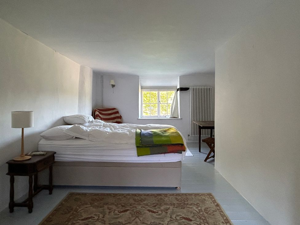 A bedroom with a bed and a table at Hole House in Branscombe