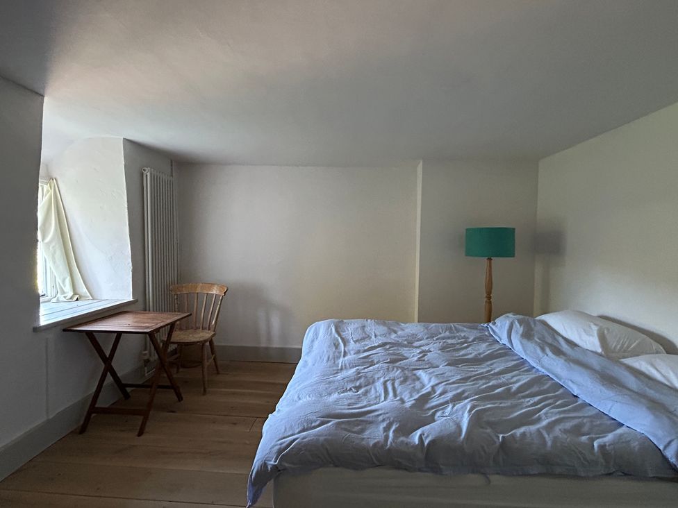 A bedroom with a bed and a table at Hole House in Branscombe