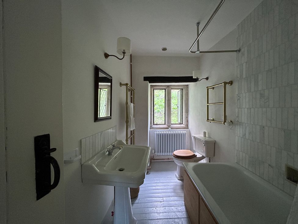 A bathroom with a sink, toilet, and bathtub at Hole House in Branscombe
