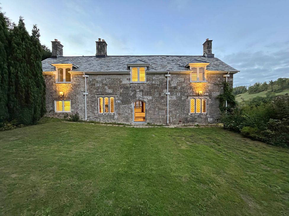 A house with windows and a door in the garden at Hole House in Branscombe