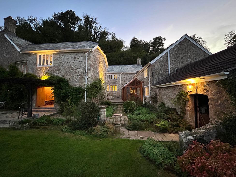 An exterior view of a stone house with garden and pathway at Hole House in Branscombe